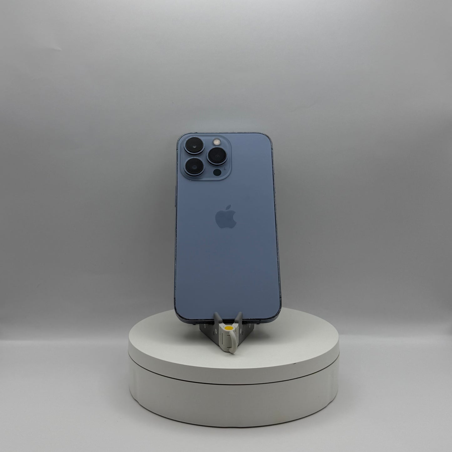 iPhone 13 Pro 128GB Sierra Blue on a turntable stand, back view
