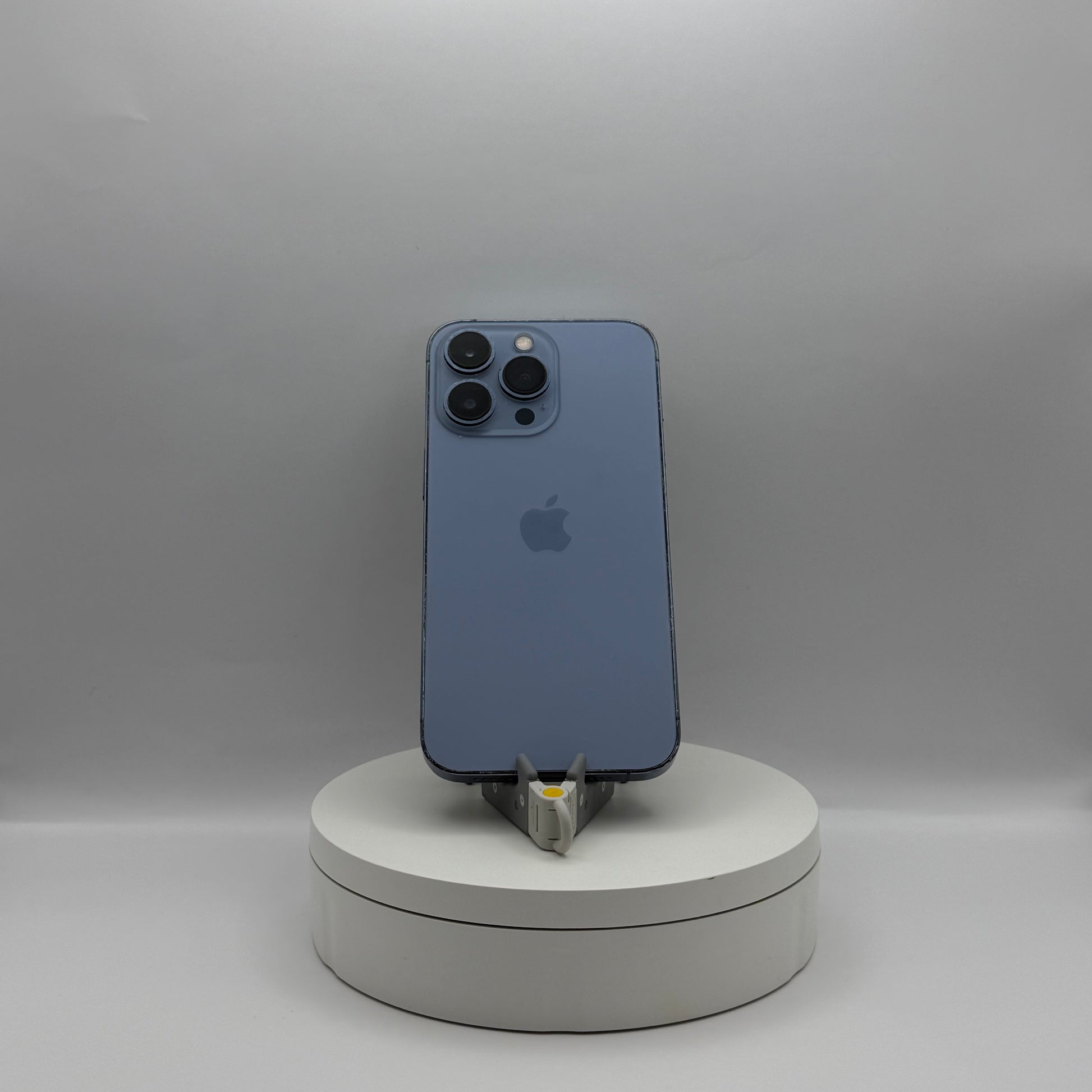 iPhone 13 Pro 128GB Sierra Blue on a turntable stand, back view